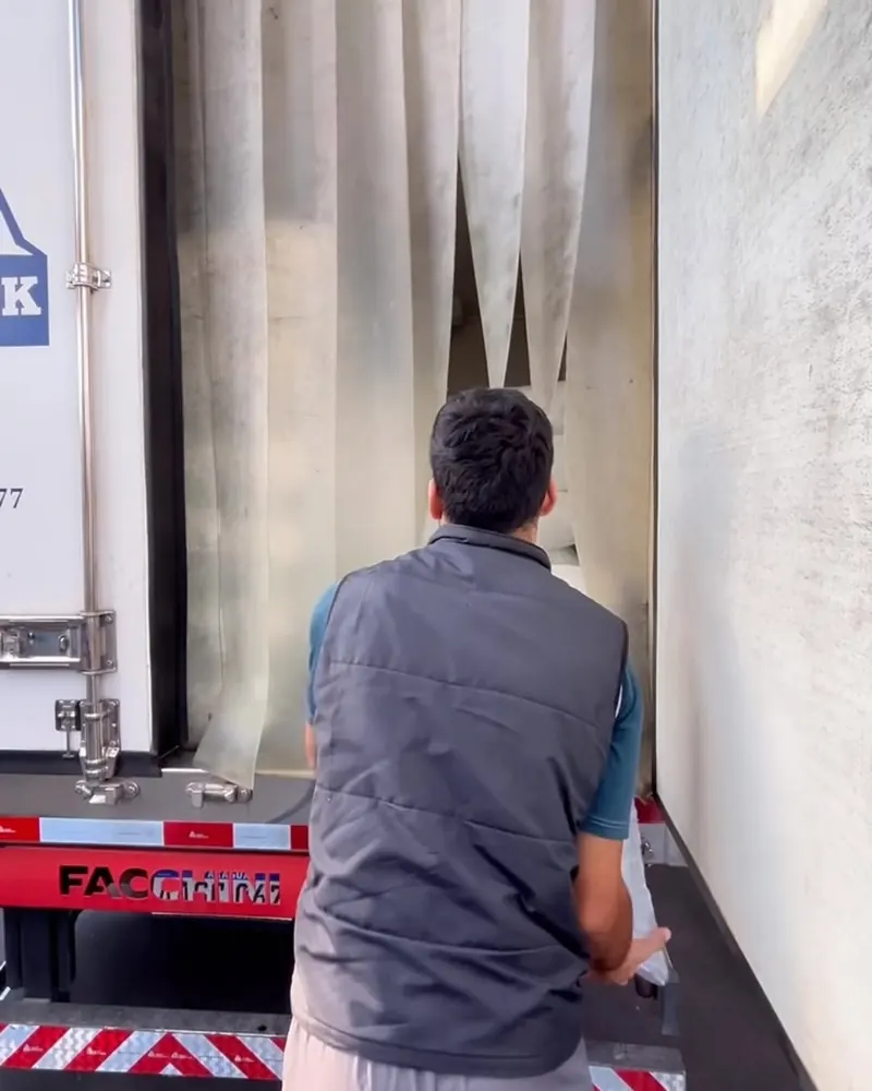 Un chofer de AspiBlock descarga bolsas de hielo del camión refrigerado en la cámara de frío de la fábrica